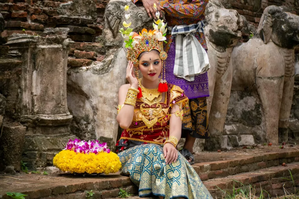 Chica balinesa vestida con traje tradicional durante una ceremonia local, reflejo de la riqueza cultural de Bali en un viaje exótico y a medida