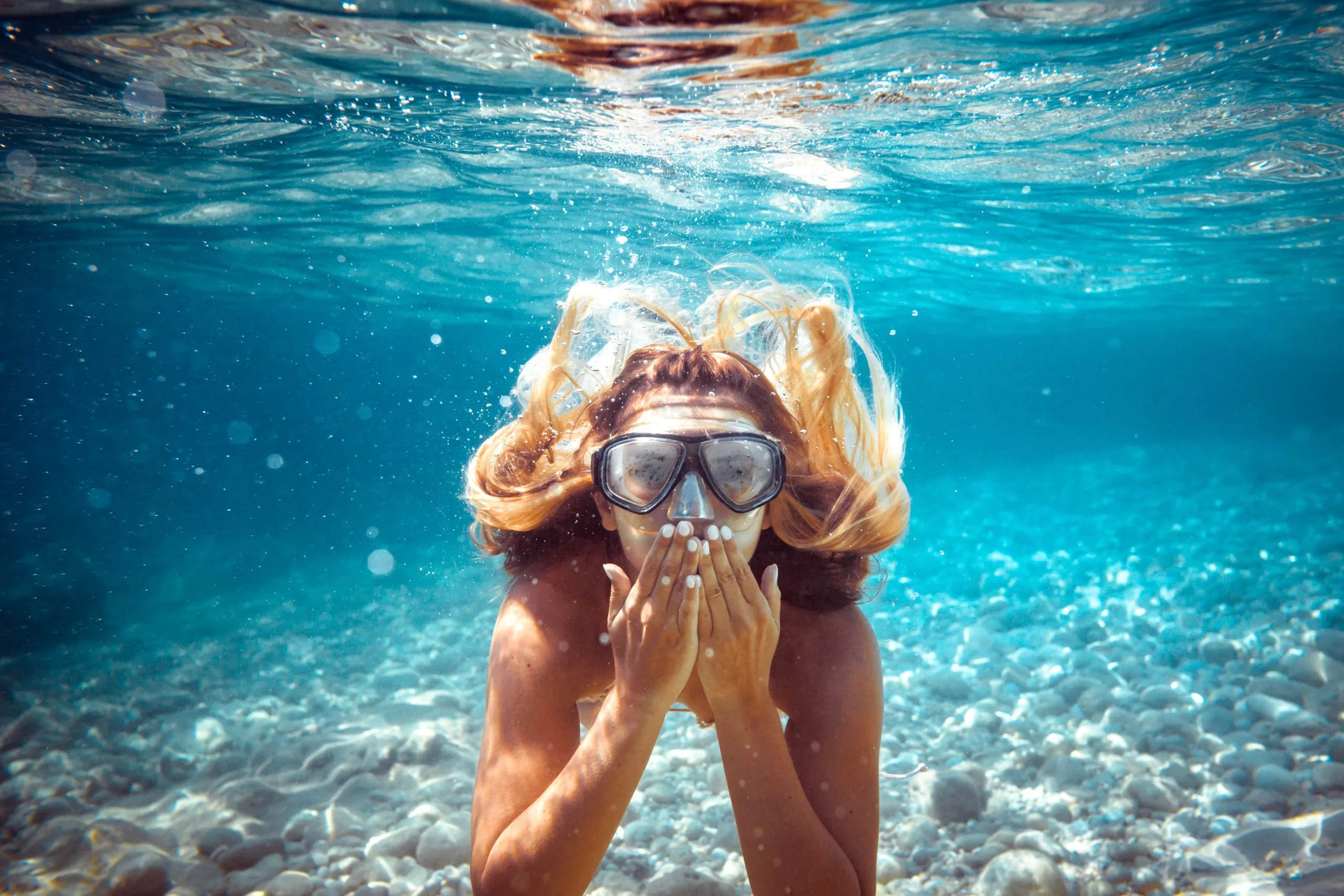 Chica haciendo snorkel en las aguas turquesas de Maldivas, una experiencia exclusiva de aventura suave en un viaje de lujo a medida