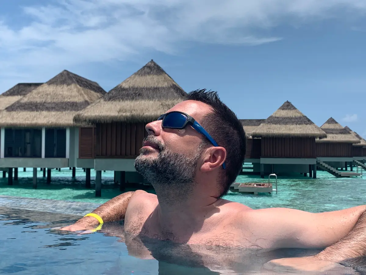Miguel de Vayara Travel en la piscina con vistas a las villas sobre el agua del hotel Pullman Maldivas