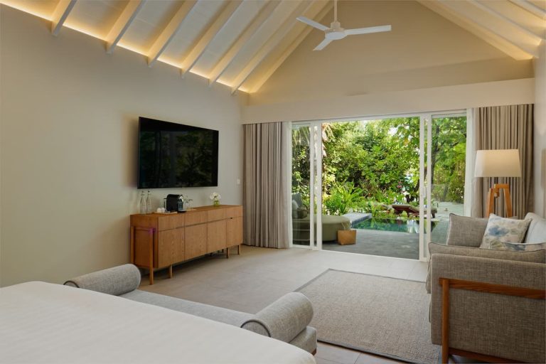 Interior de una Beach Villa with Pool en RAAYA by Atmosphere, Maldivas, con dormitorio elegante y vistas a la piscina privada en Raa Atoll.
