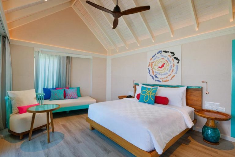 Interior de una Sunset Water Villa with Pool en OBLU NATURE Helengeli by SENTIDO, Maldivas, con dormitorio luminoso y elegante sobre el agua en North Malé Atoll.