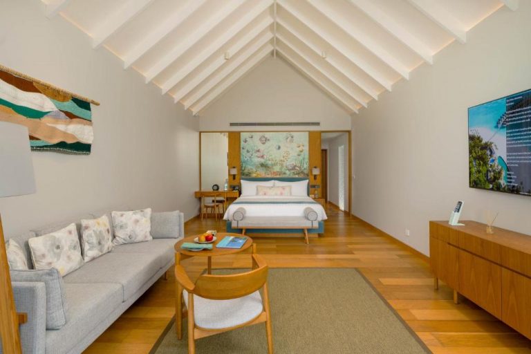 Interior elegante de una Water Villa en RAAYA by Atmosphere, Maldivas, con dormitorio amplio, diseño sofisticado y ambiente luminoso sobre el agua.